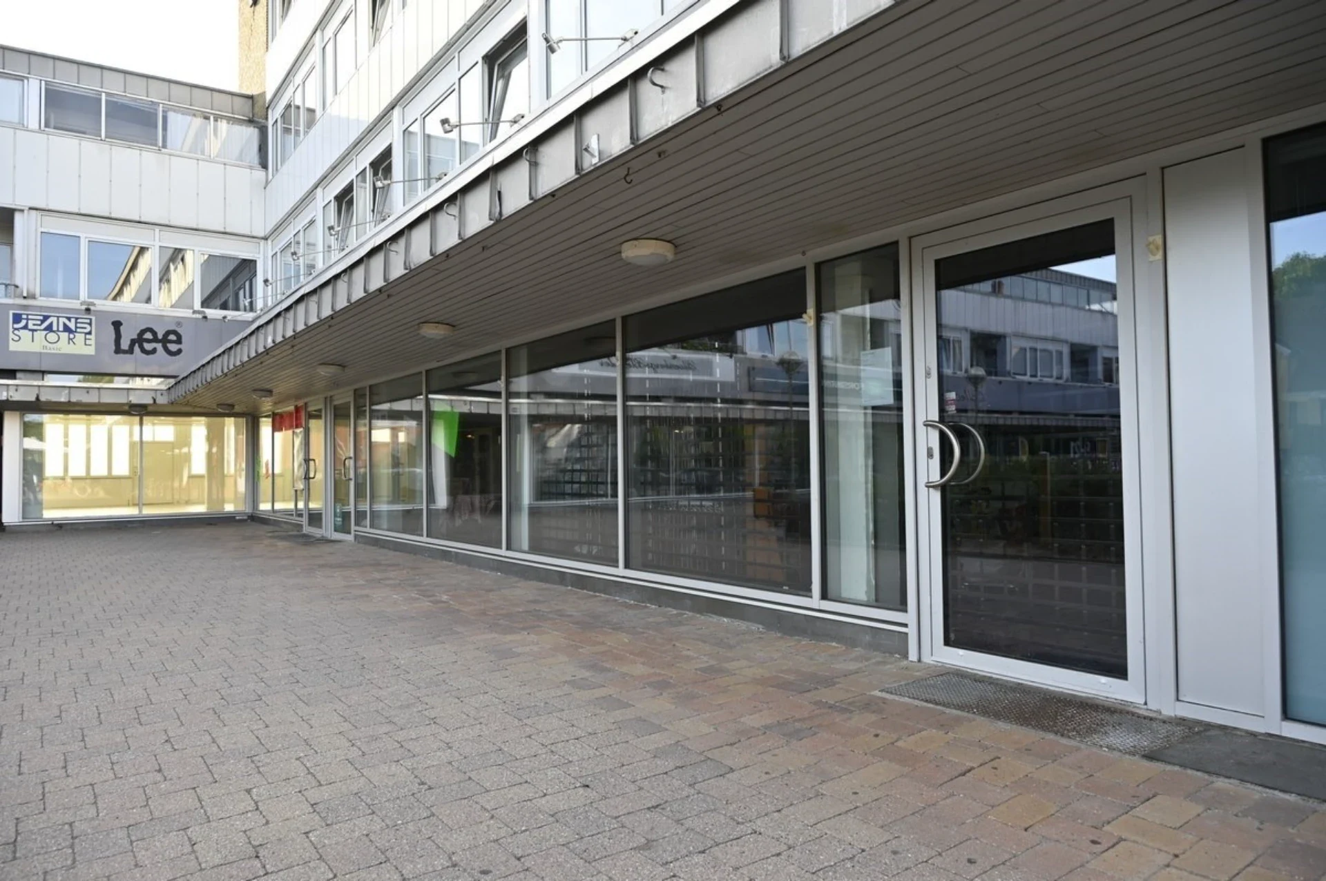 Moderne kontorbygning med store glasfacader og indgangsdør.