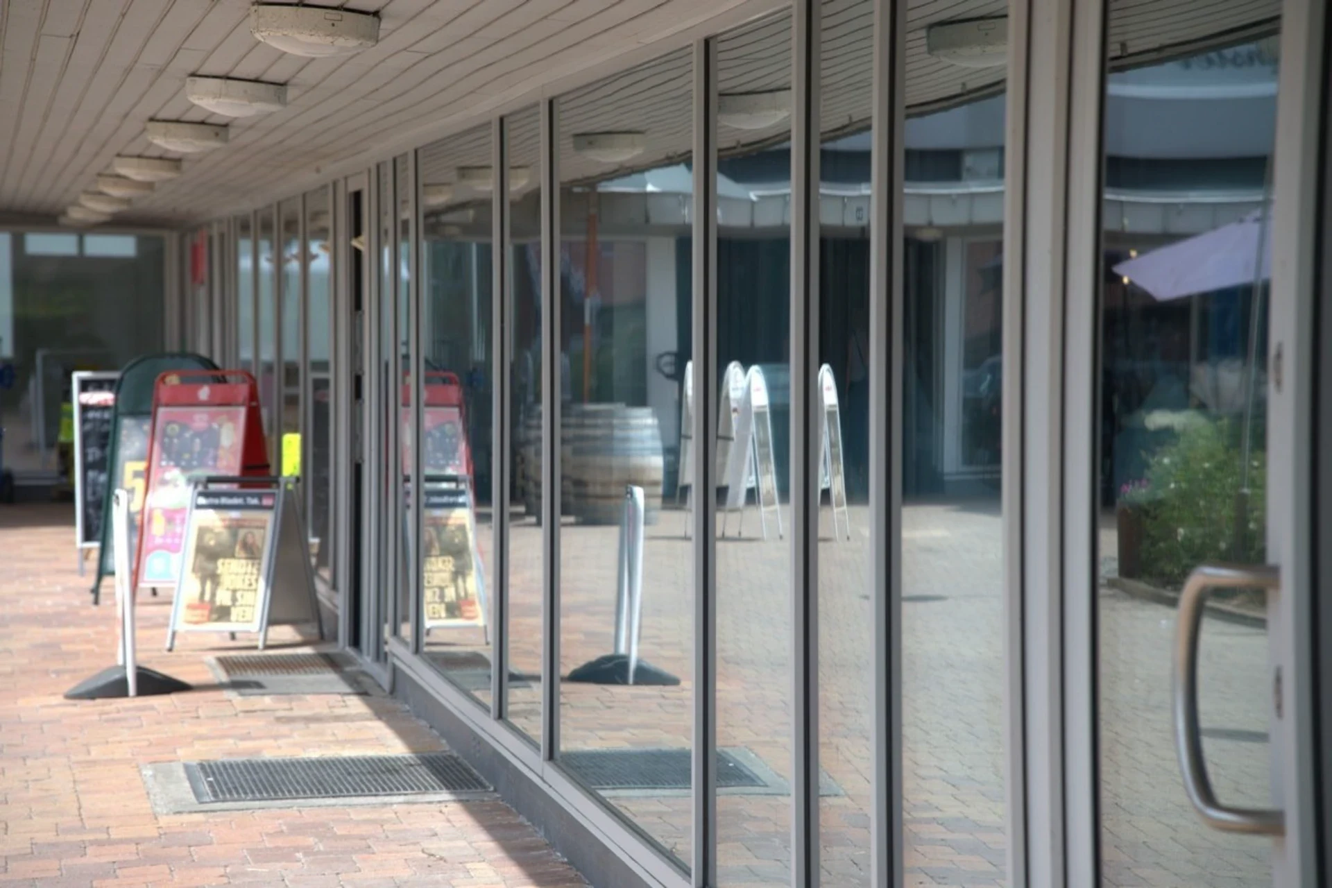 Butiksfacade med store glasvinduer og indgangsdøre.