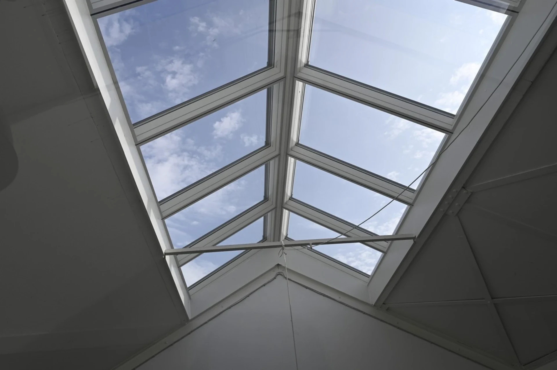 Moderne glas tagkonstruktion med udsigt til himlen.