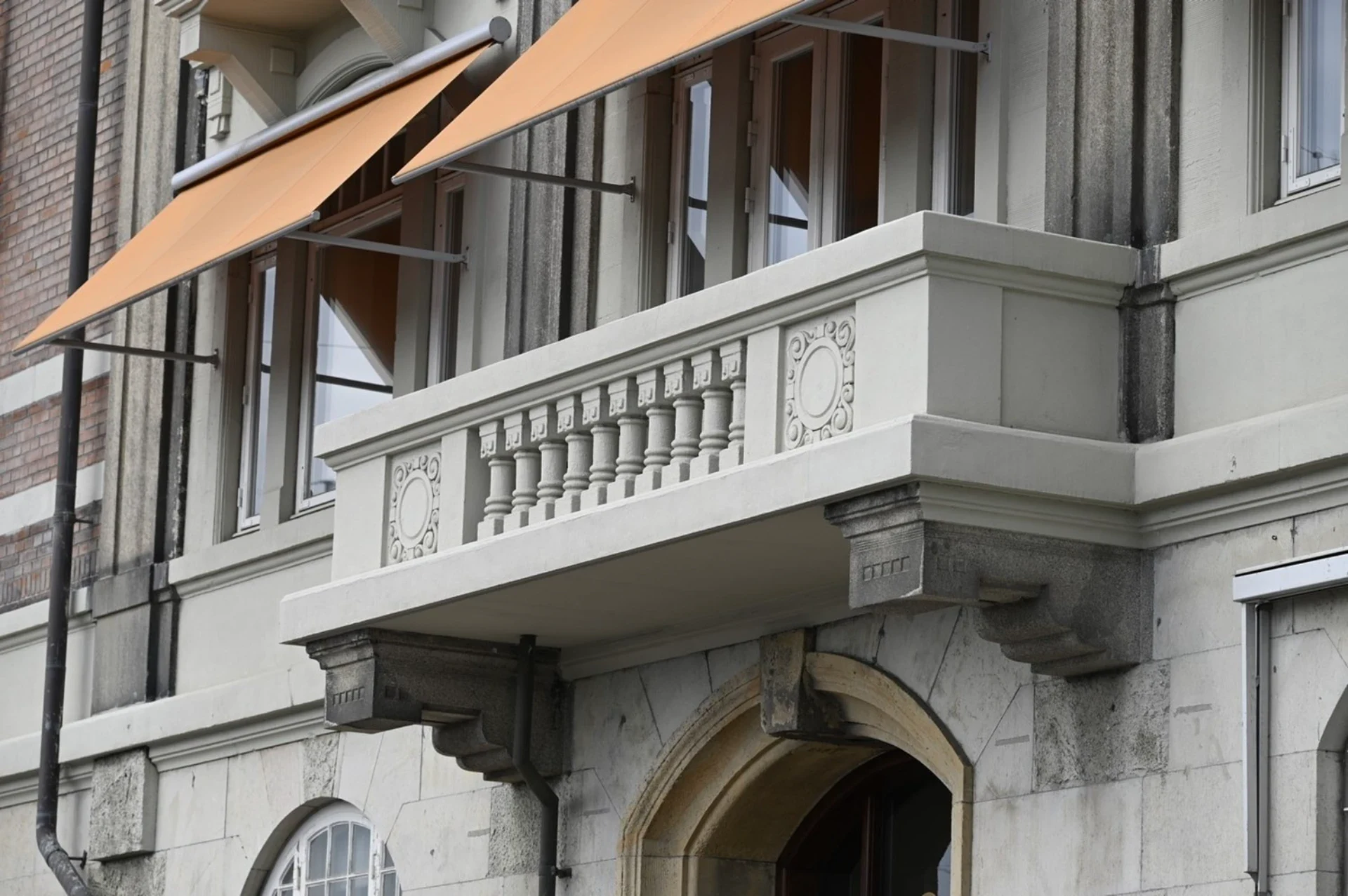Klassisk bygning med balkon og arkitektoniske detaljer.