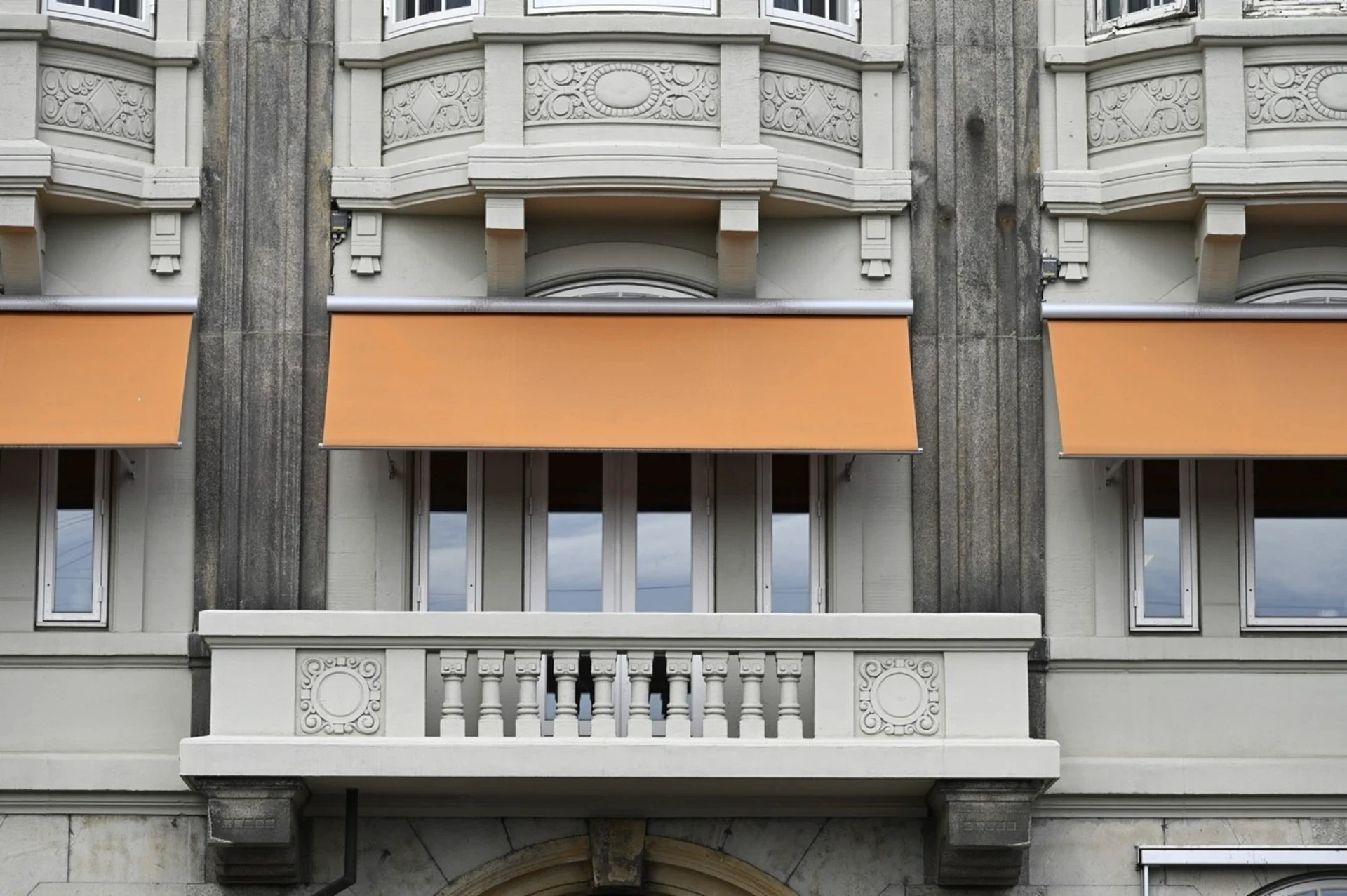Husfacade med balkon og markise.