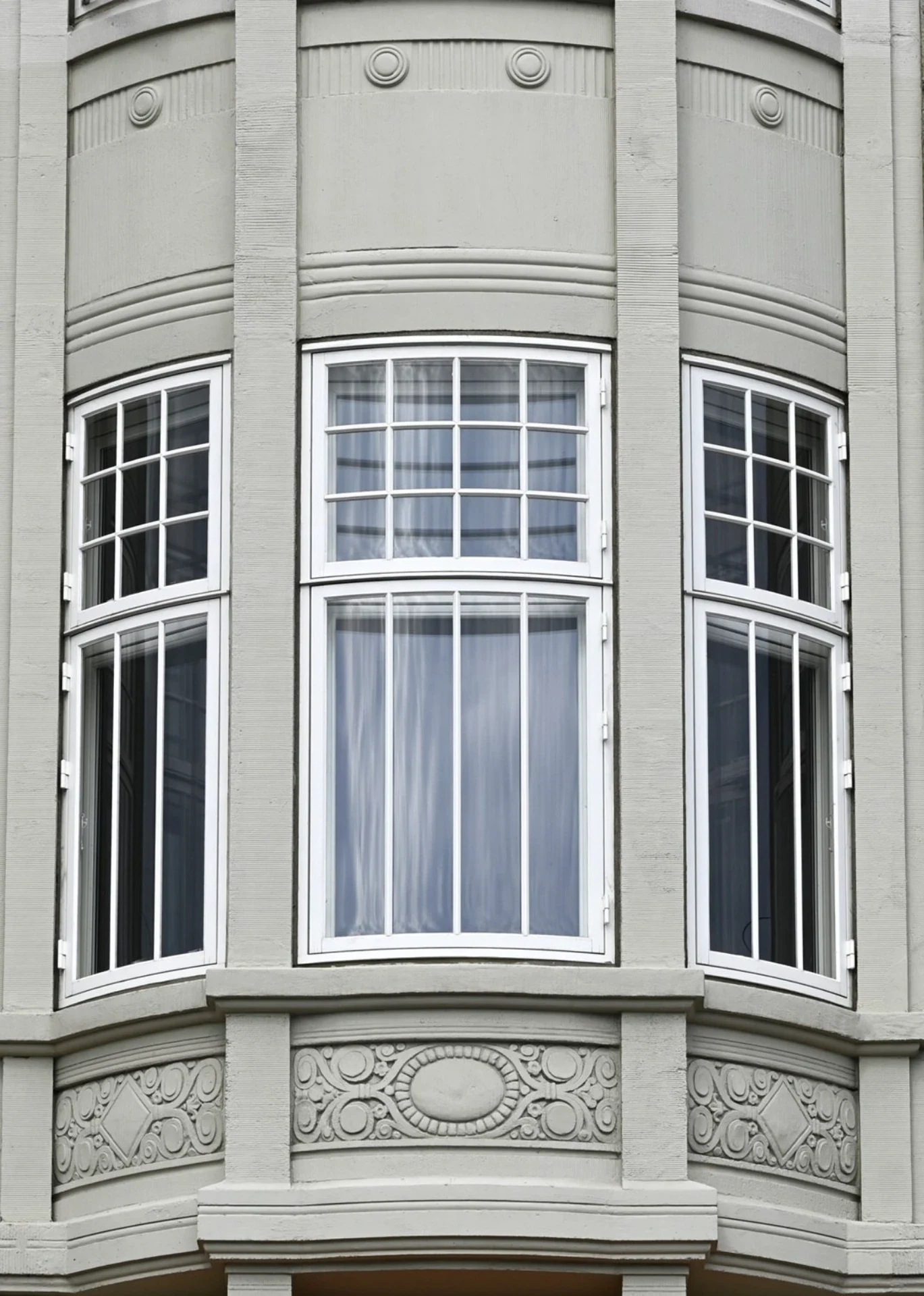Smuk husfacade med store, hvide vinduer og klassisk arkitektur.