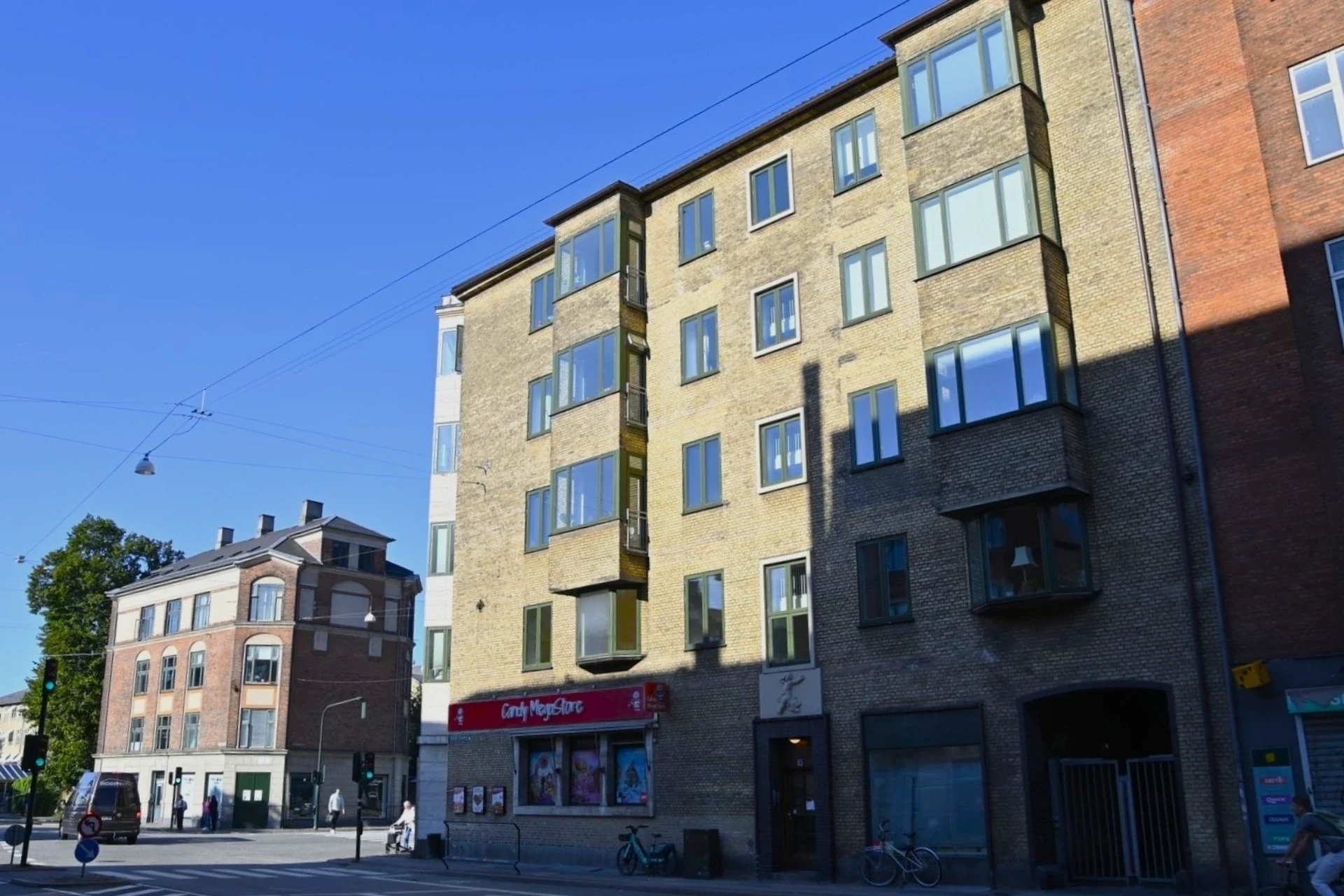 Bred ALT tekst med fokus på boligbyggeri og bymiljø, der fremhæver bygningens arkitektur og beliggen.