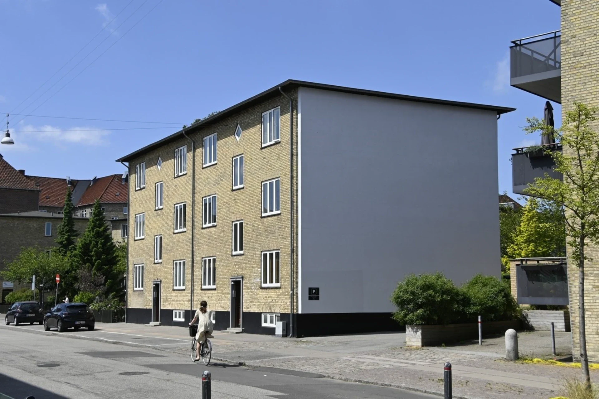 Moderne boligbyggeri i centrum med lyse facader og grønne områder.
