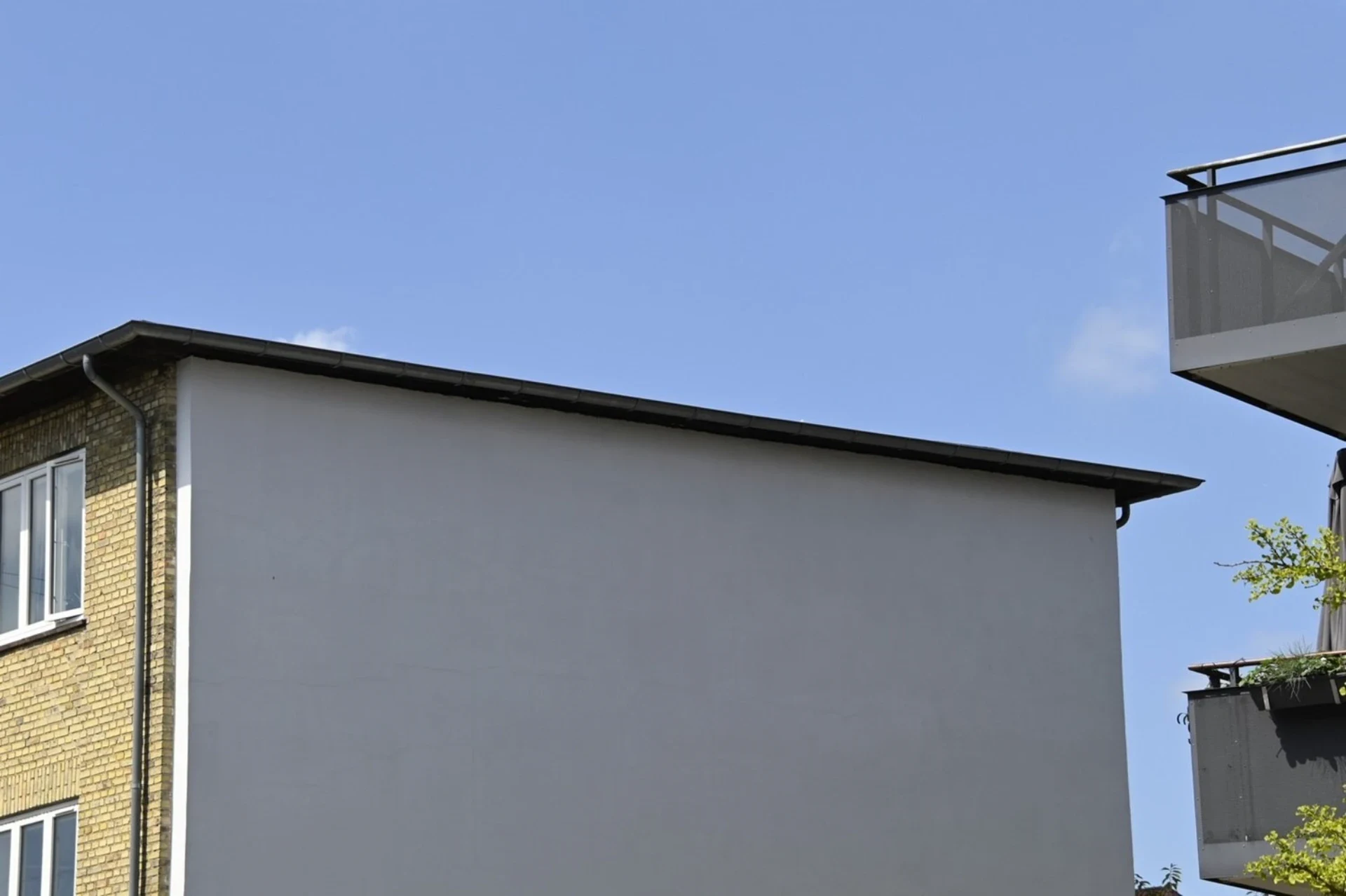 Moderne boligbyggeri med enkel facadedesign og balkon.