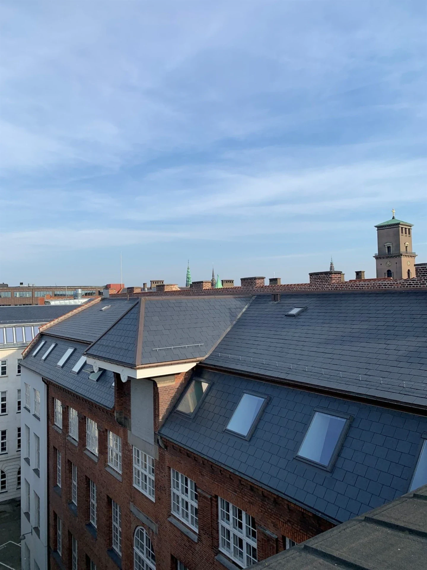 Billede af nye tagvinduer og tagdækning på en byejendom i København.